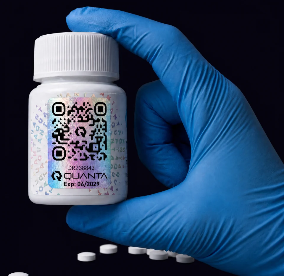 Quanta bottle held in a gloved hand, showing the holographic verification seal